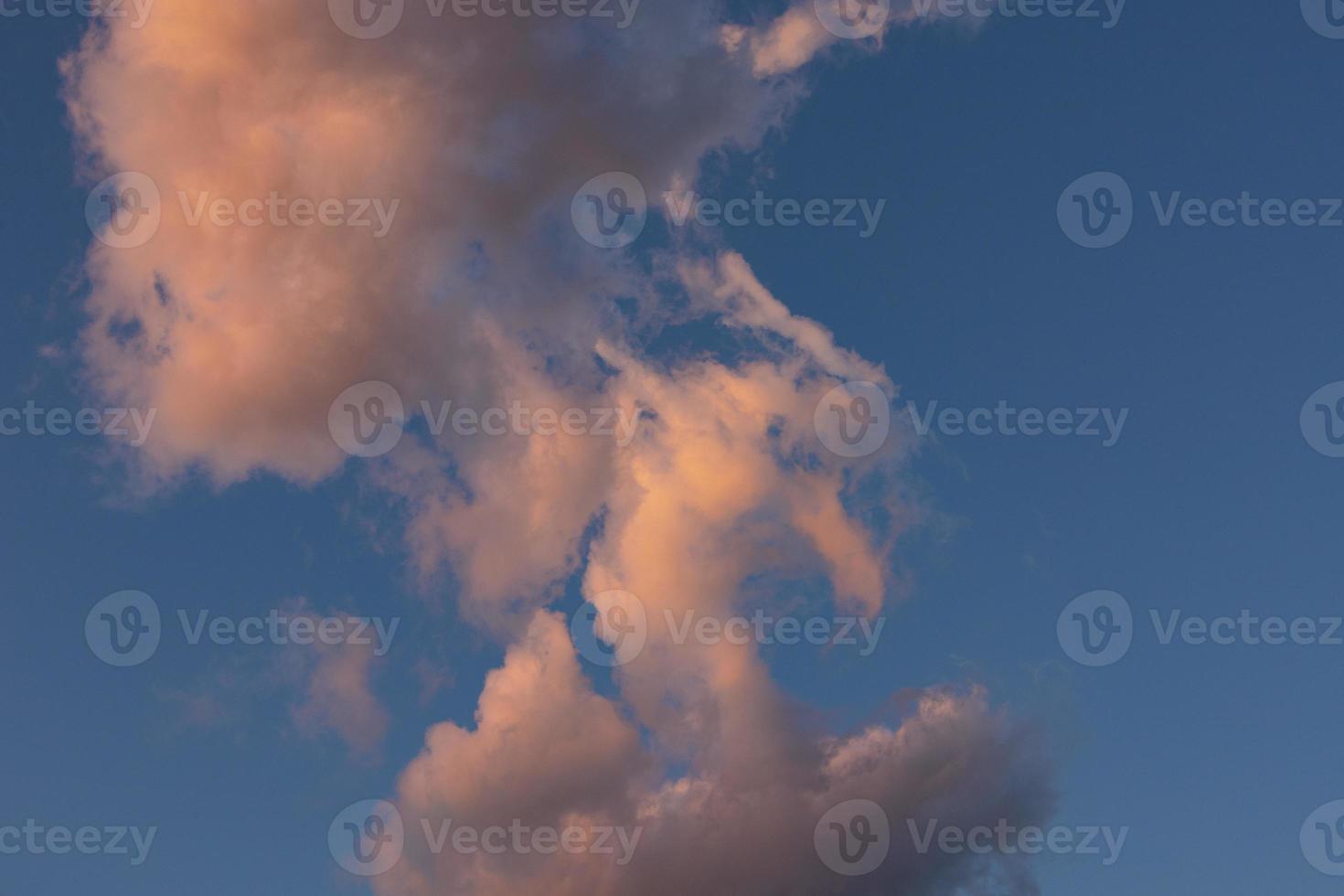 wolk landschap. roze en bruin zomer cumulus wolken Aan een blauw lucht gedurende zonsondergang. behang. achtergrond. foto