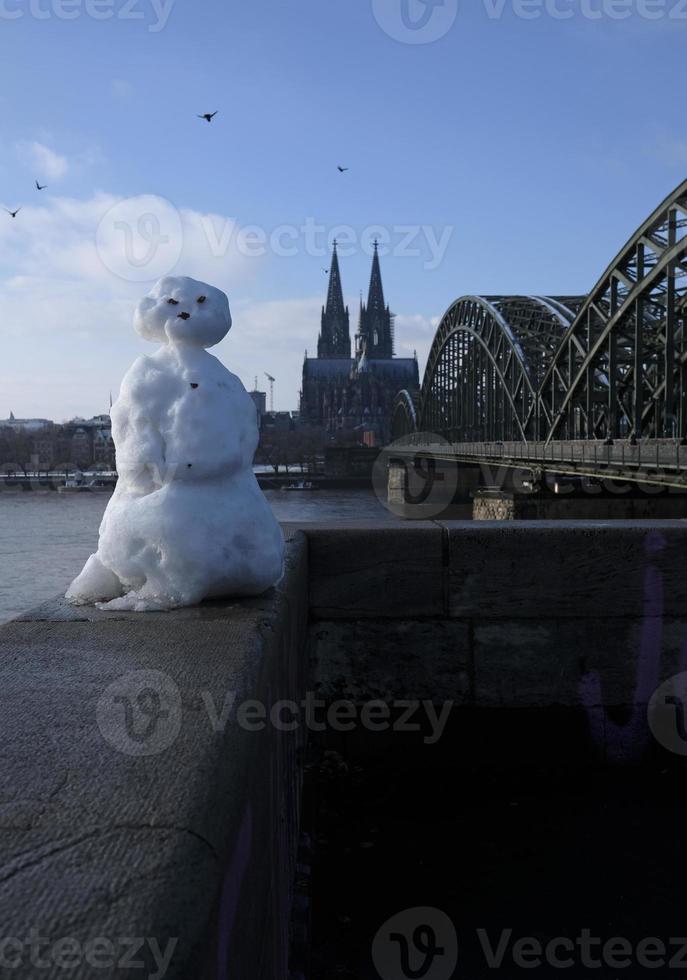 een sneeuwman in Keulen, duitsland, met de beroemd kathedraal in de achtergrond foto