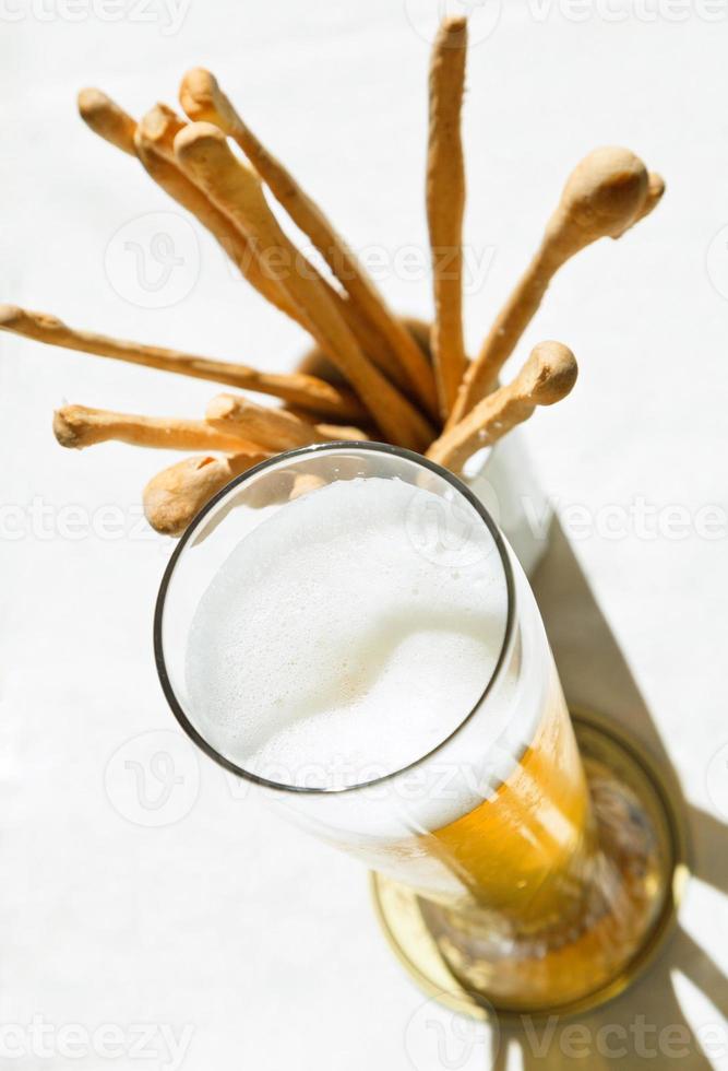 bovenstaand visie glas van bier en brood stokjes foto