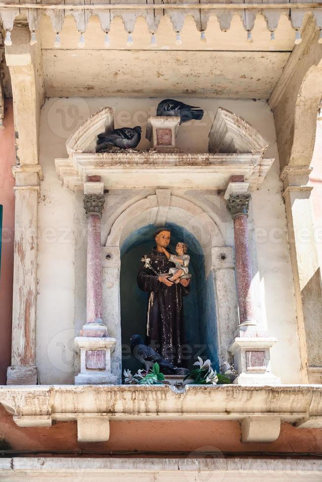 beeldhouwwerk van een heilige in stedelijk huis in Venetië foto