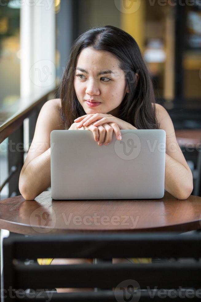 Aziatische vrouw die gelukkig een notitieboekje gebruikt foto