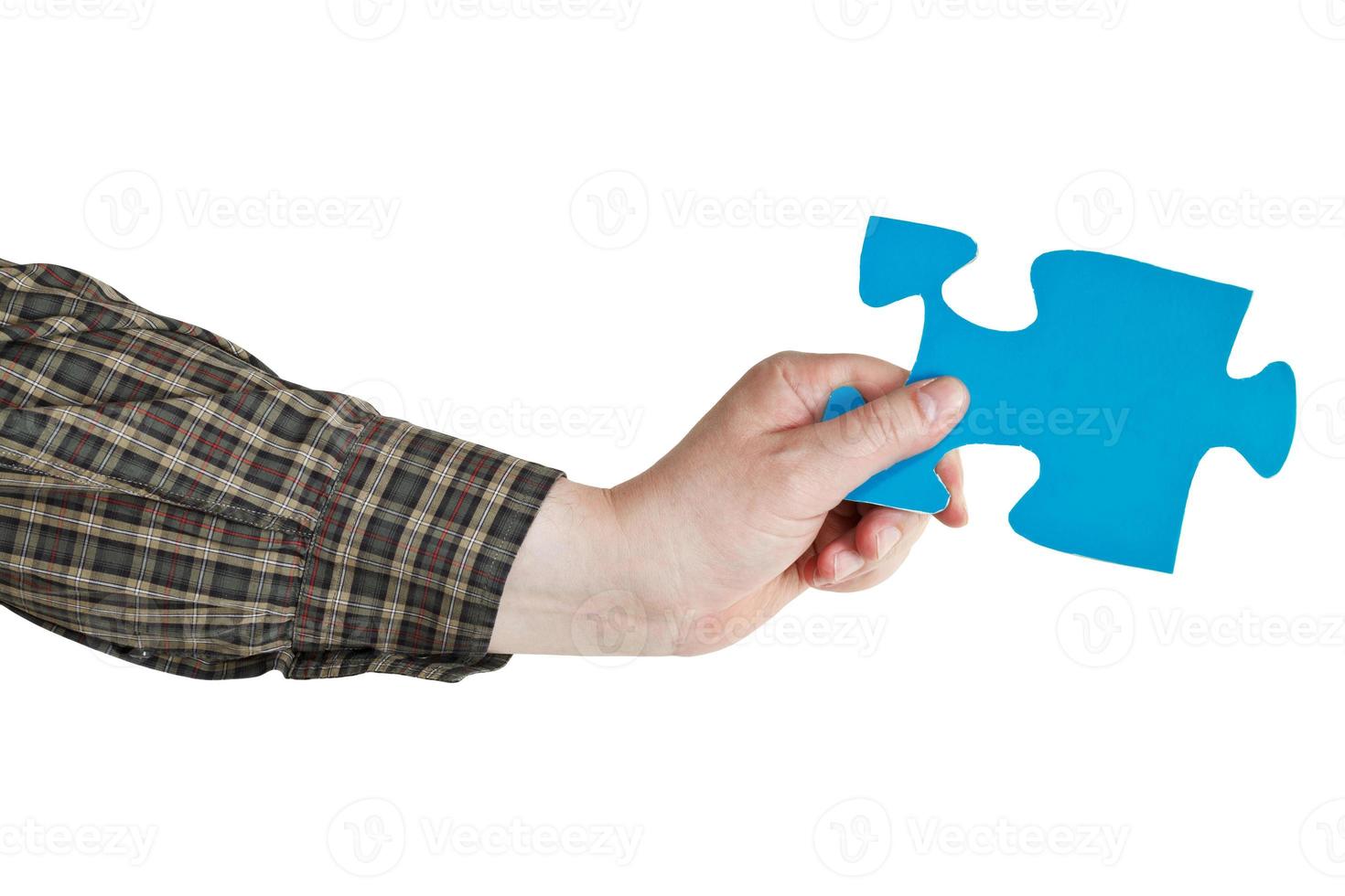 mannetje hand- Holding groot blauw papier puzzel stuk foto