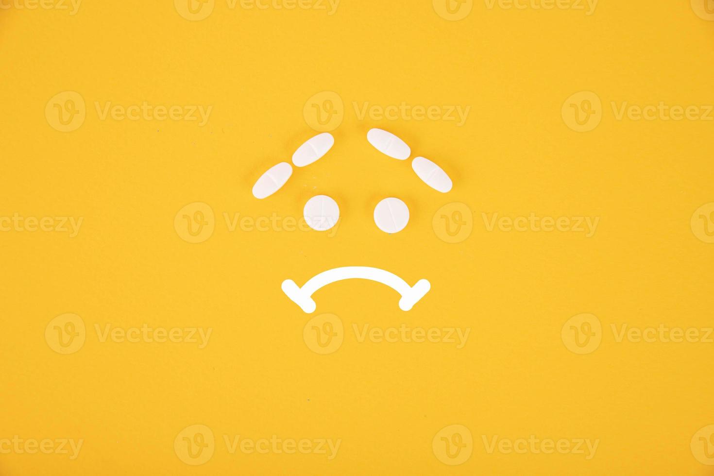 de pillen zijn gestapeld in de het formulier van een verdrietig smiley Aan een geel achtergrond. copyspace foto