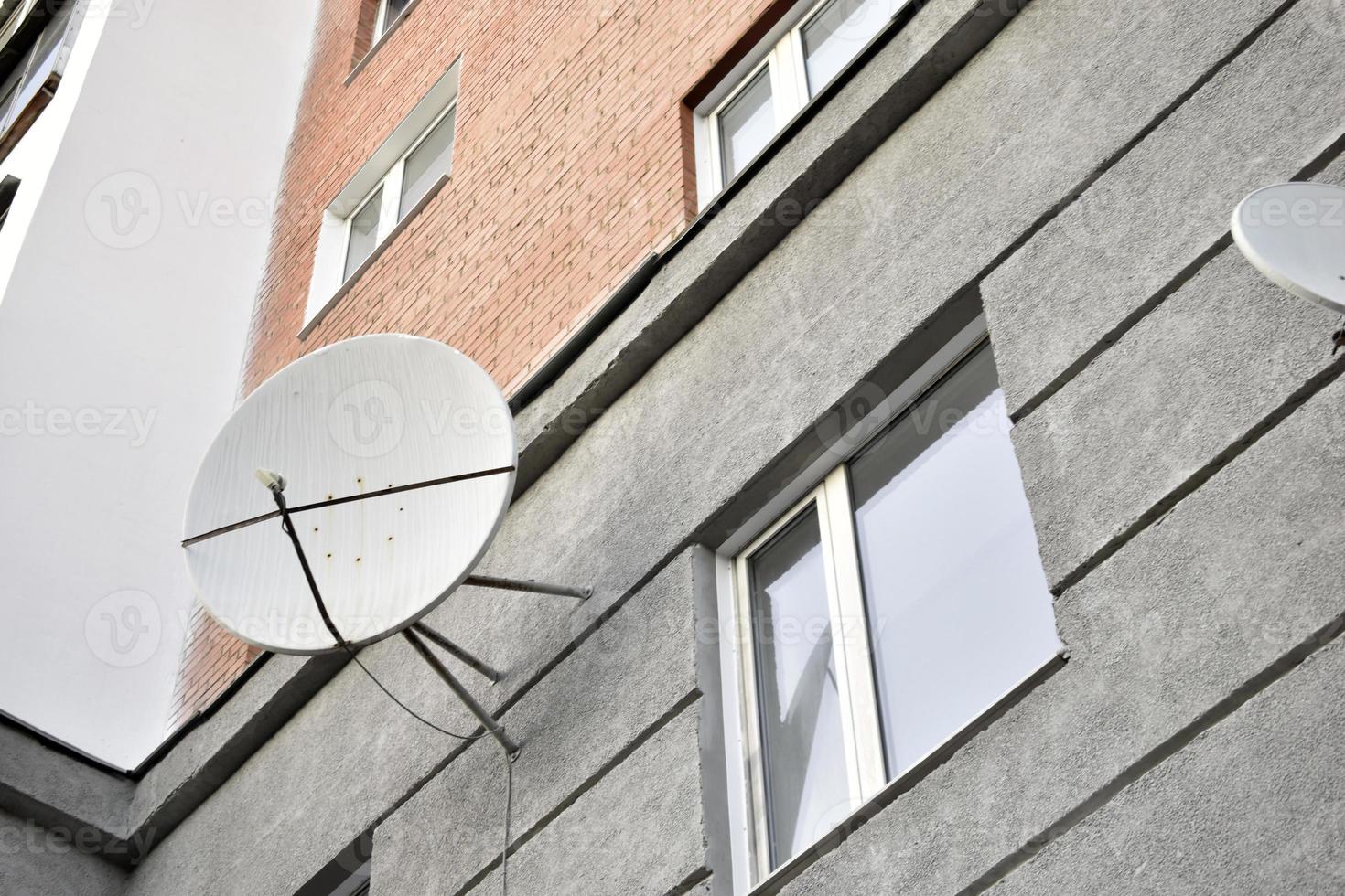 satelliet schotel Aan een grijs gebouw detailopname. een parabolisch antenne Aan de muur. foto