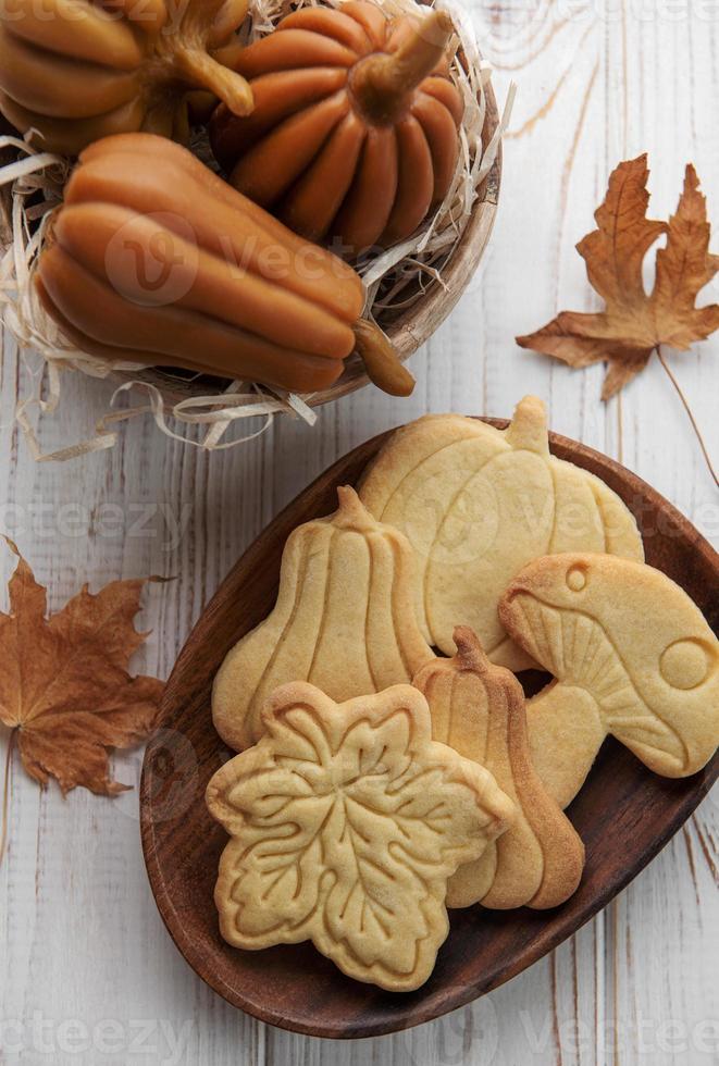 koekjes vormig Leuk vinden pompoen en bladeren Aan rustiek hout achtergrond foto