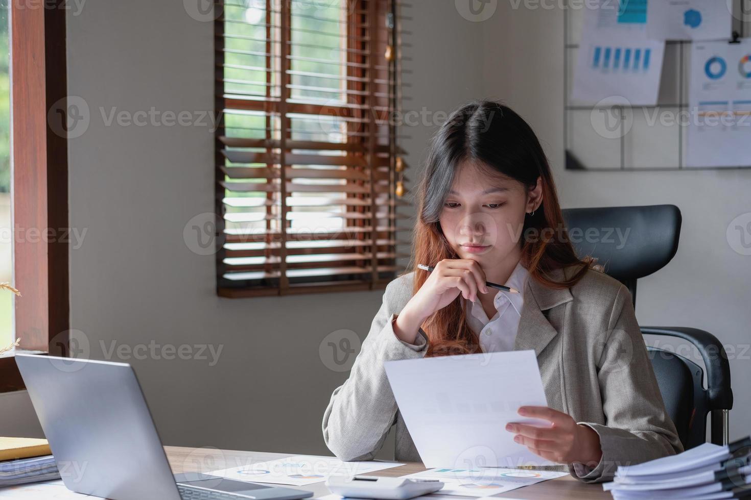 marketing, financiën, boekhouding, planning, vrouw accountant gebruik makend van laptop rekenmachine en documenten, grafieken, grafieken in de analyse van de van het bedrijf winst foto