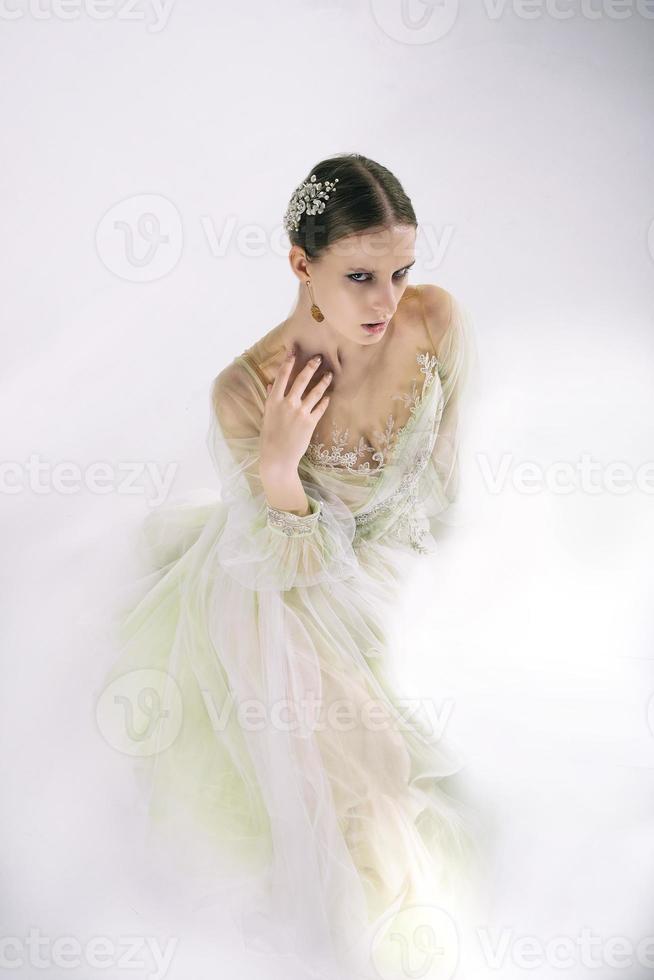 jong meisje model- in een foto studio in een bruiloft jurk gebaren met haar handen poseren van een top hoek