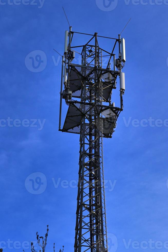 elektrisch antenne en communicatie zender toren in een noordelijk Europese landschap tegen een blauw lucht foto