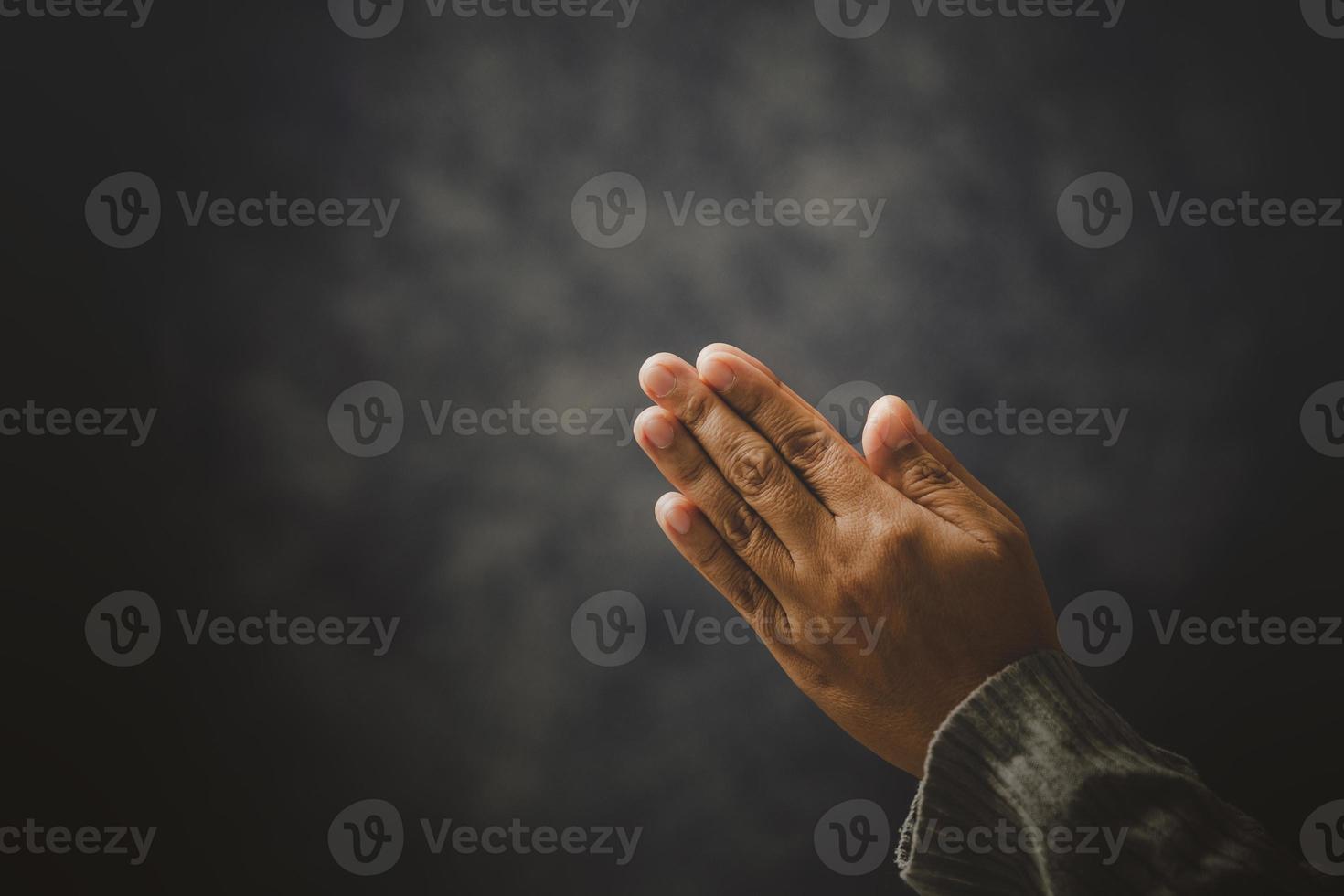 gebed persoon hand- in zwart achtergrond. christen Katholiek vrouw zijn bidden naar god in donker Bij kerk. meisje van mening zijn en geloof in Jezus Christus. Christus religie en Christendom aanbidden of bidden concept. foto