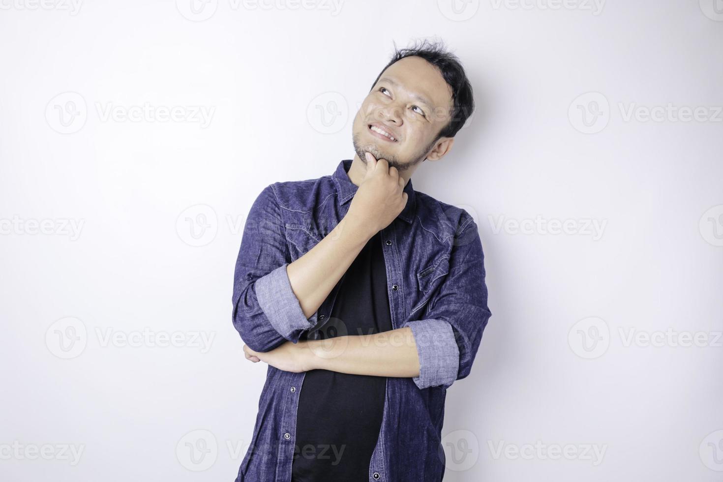 portret van een attent jong Aziatisch Mens vervelend marine blauw overhemd op zoek terzijde benieuwd keuzes foto