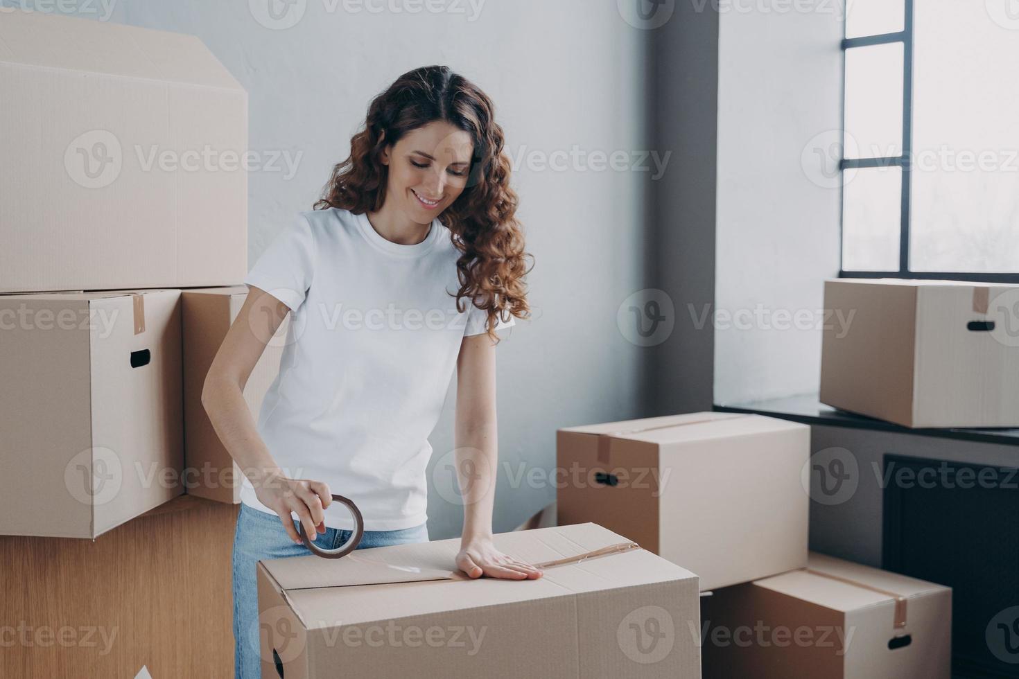 vrouw gebruik makend van Zelfklevend plakband, inpakken karton pakket doos. reclame van verwijdering onderhoud, levering foto
