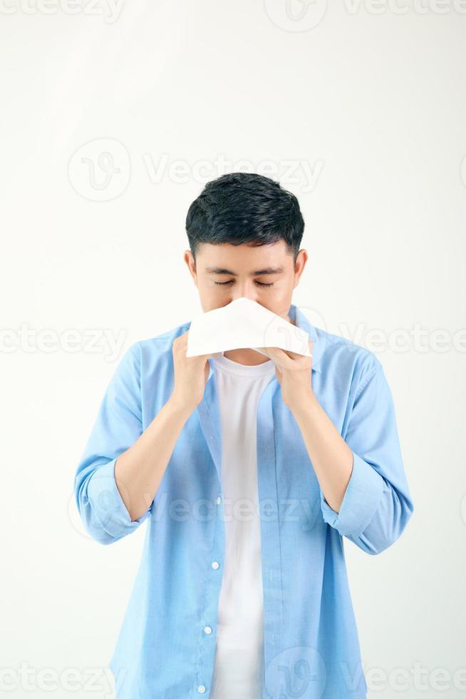 jong Aziatisch Mens niezen na krijgen allergie of griep virus en gebruik makend van zakdoek papier voor vegen Aan neus- Bij medisch kliniek na kreeg coronavirus ziekte voor ongezond levensstijl concept foto