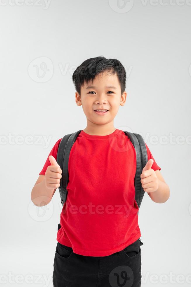 gelukkig jong Aziatisch school- jongen met duimen omhoog geïsoleerd Aan een wit achtergrond. foto