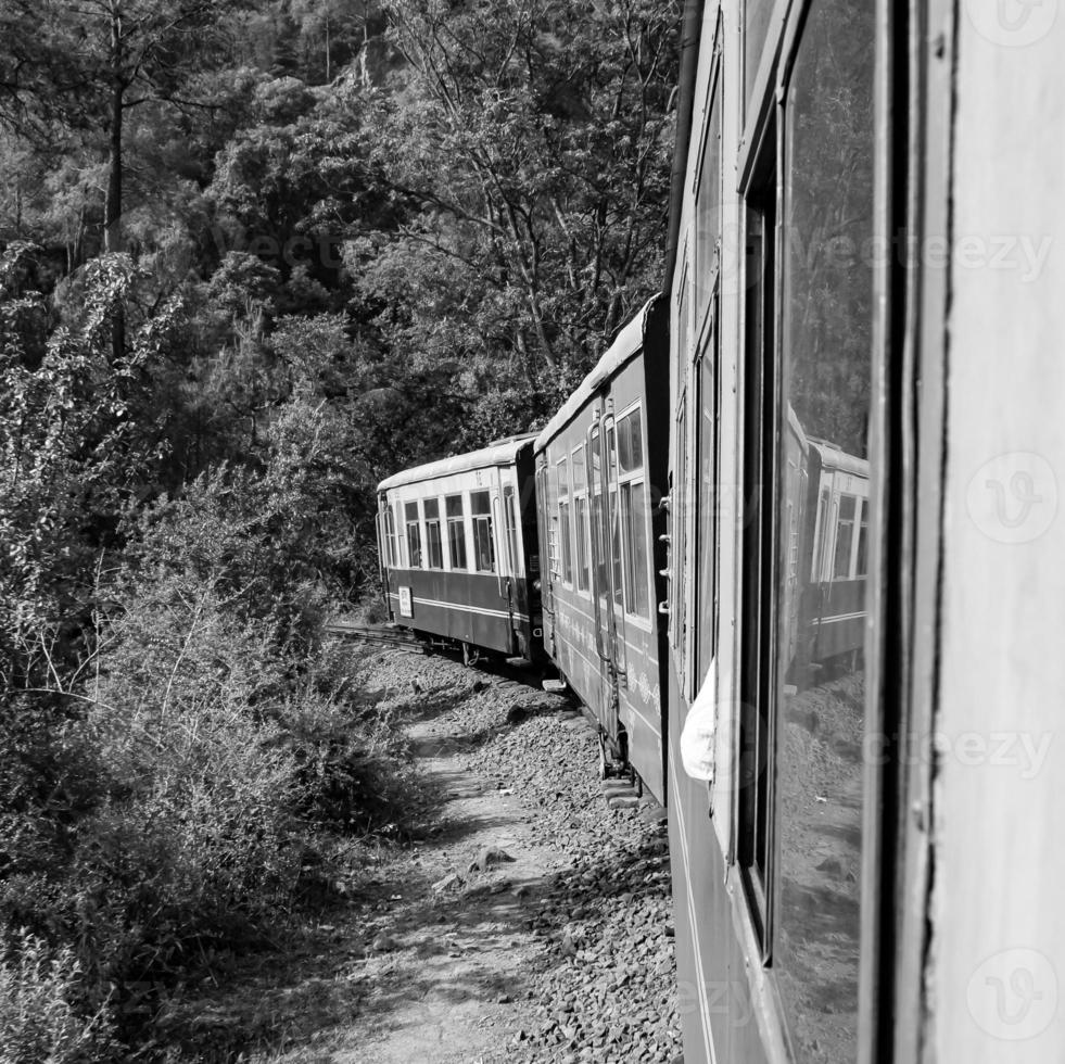 speelgoed- trein in beweging Aan berg helling, mooi visie, een kant berg, een kant vallei in beweging Aan spoorweg naar de heuvel, tussen groen natuurlijk bos.speelgoed trein van kalka naar shimla in india-zwart en wit foto