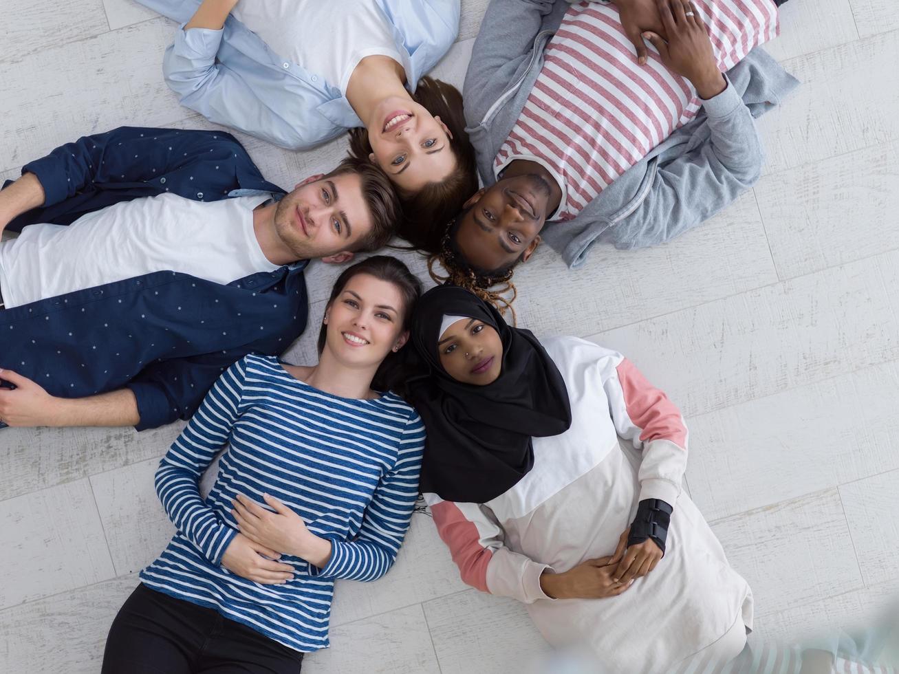 top visie van een verschillend groep van mensen aan het liegen Aan de verdieping en symboliseert saamhorigheid foto