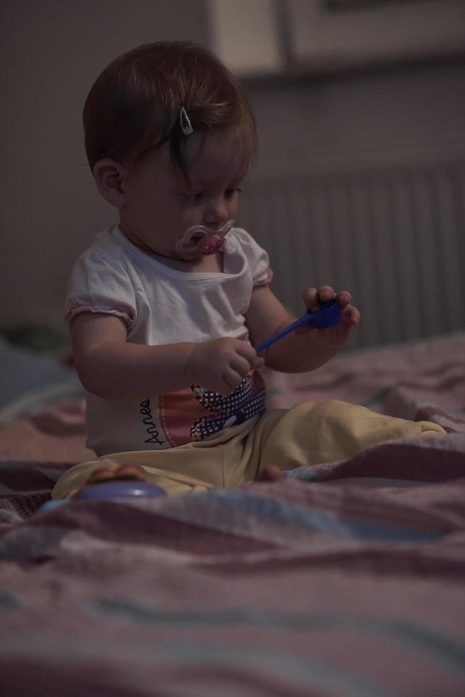 schattig weinig een jaar oud baby en maken eerste stappen in bed foto