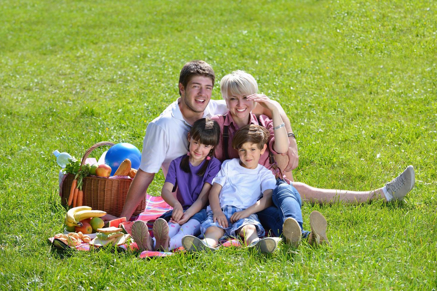 gelukkig familie spelen samen in een picknick buitenshuis foto