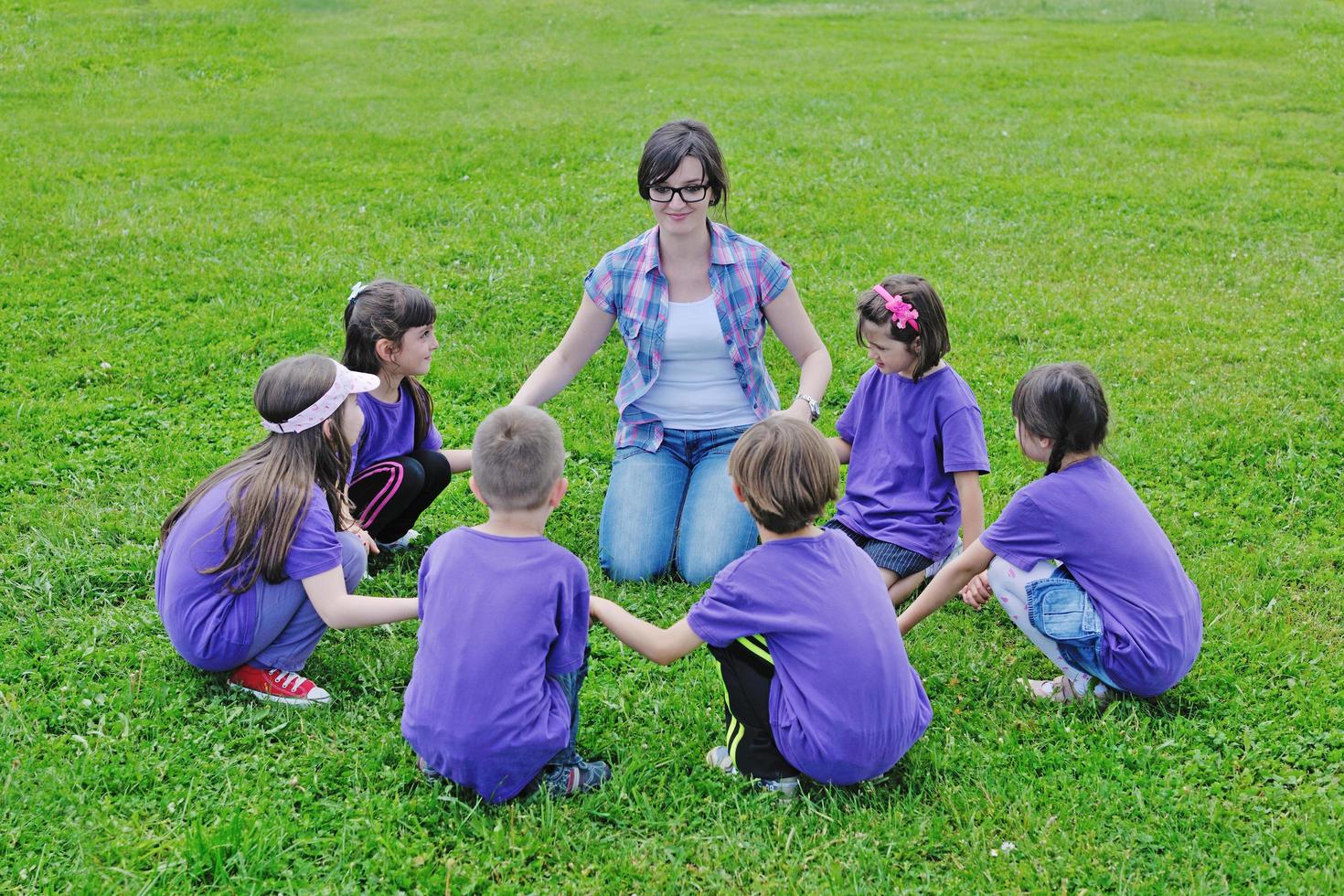 groep gelukkige kinderen met leraar in de natuur foto