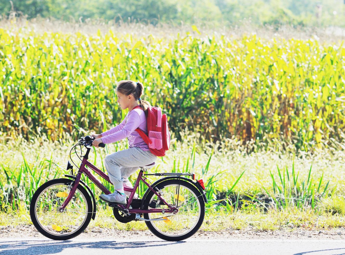 schoolmeisje op reis naar school- Aan fiets foto