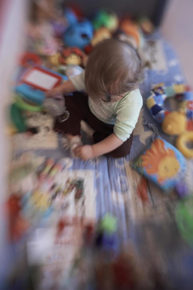 schattig weinig baby spelen in mobiel bed foto