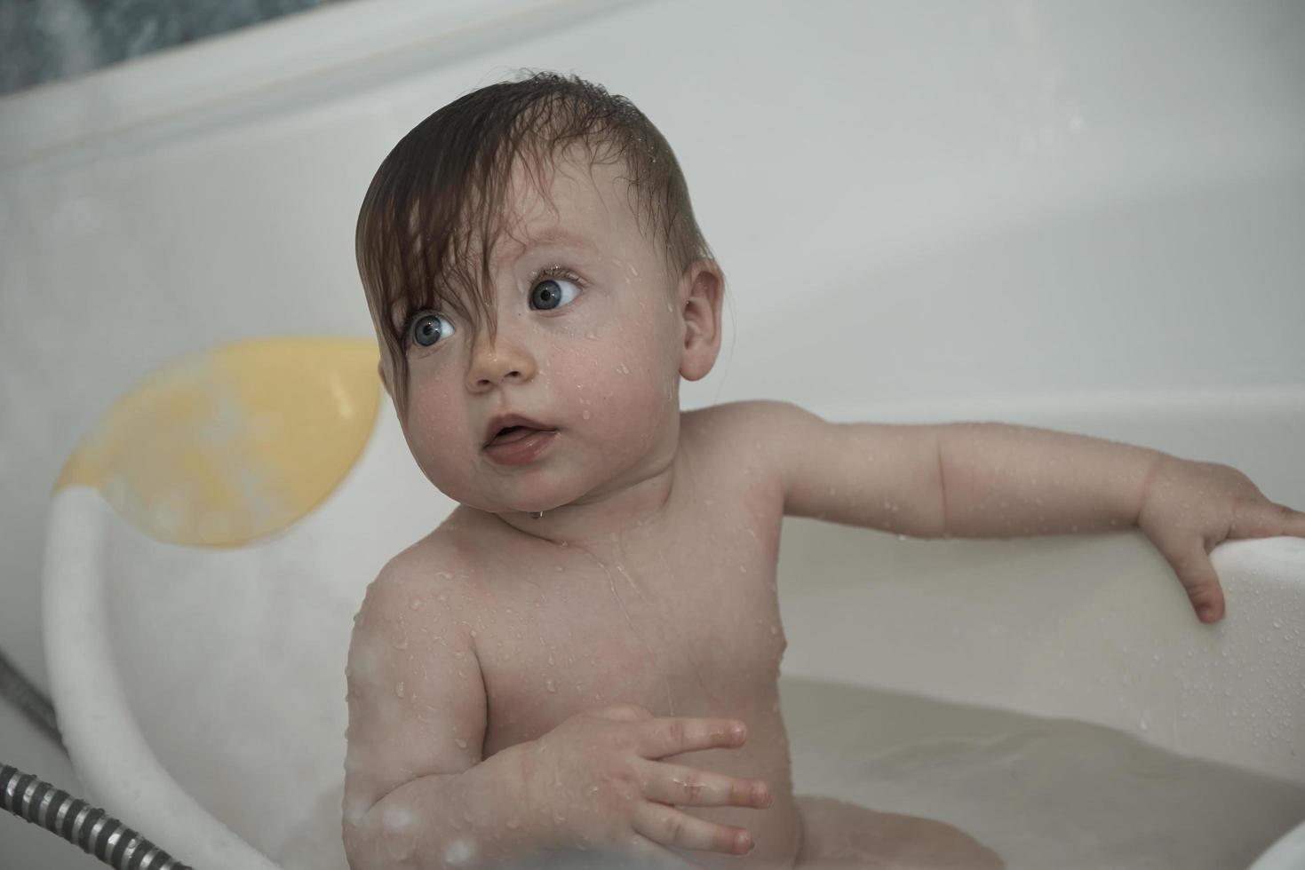 schattig weinig baby meisje nemen een bad foto