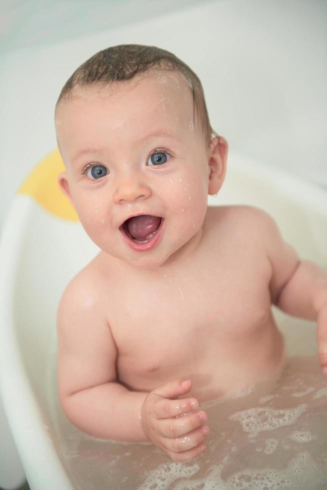 schattig weinig baby meisje nemen een bad foto