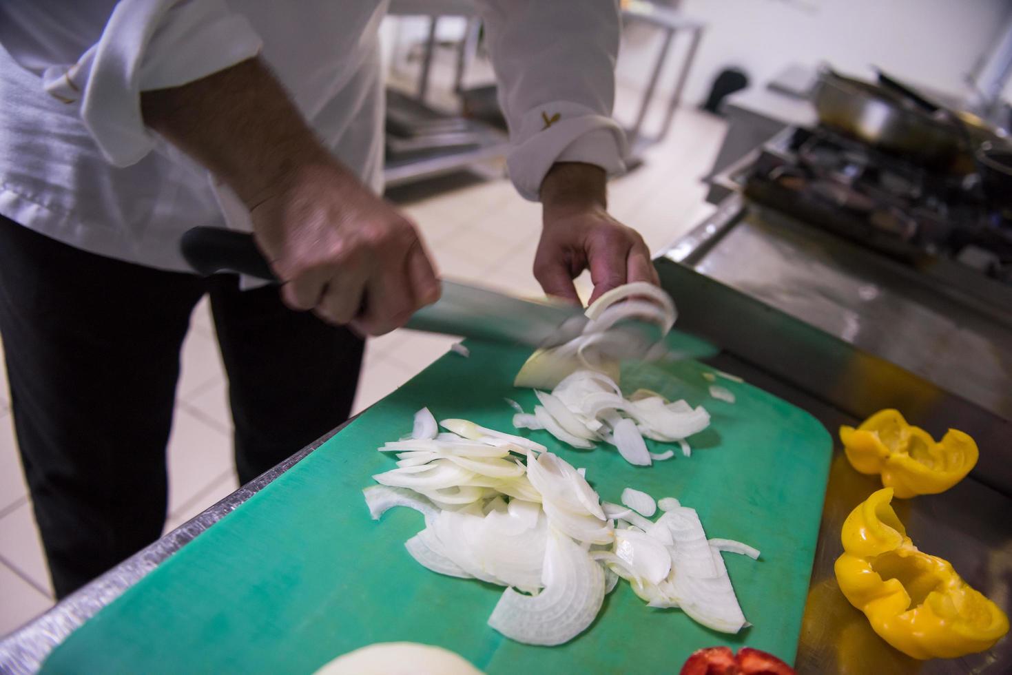 chef-kok handen snijden verse en heerlijke groenten foto