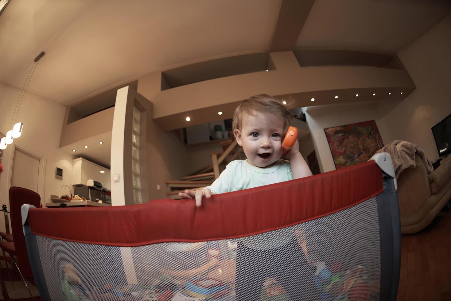 schattig weinig baby spelen in mobiel bed foto