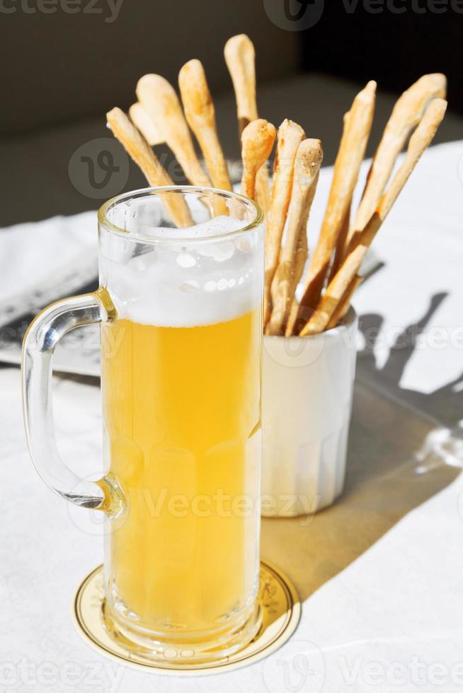 mok van bier en brood stokjes Aan tafel foto