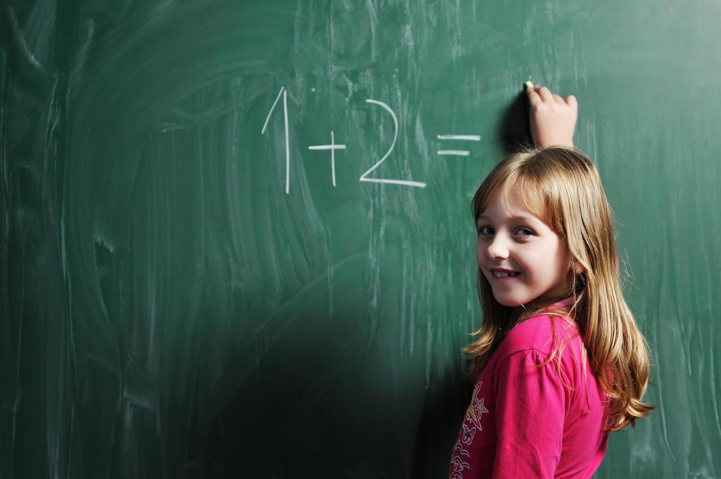 gelukkig school- meisje Aan wiskunde klassen foto