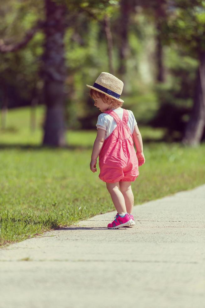 klein meisje rent in het zomerpark foto