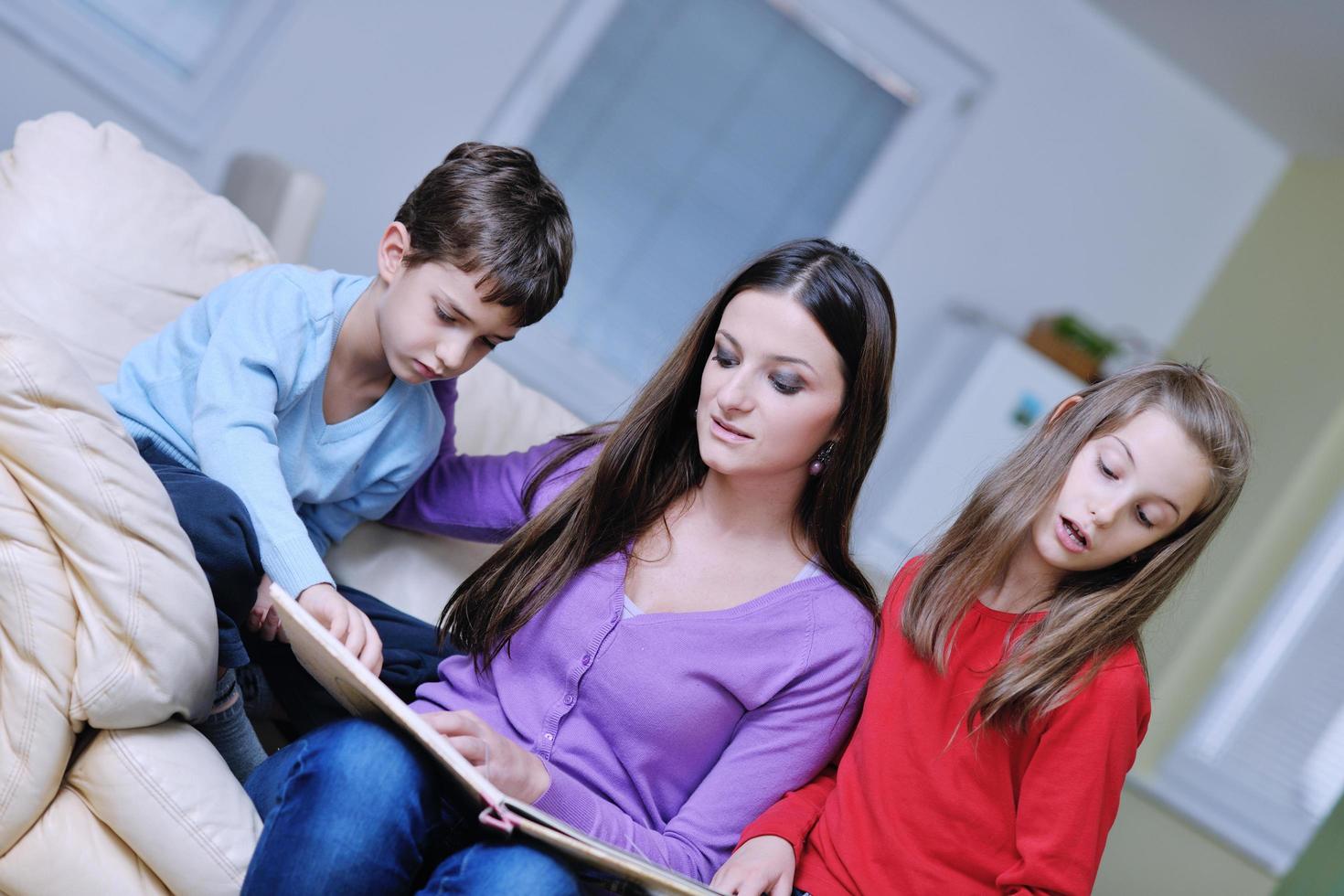 jong mam Speel met hun kinderen Bij huis en lezing boek foto