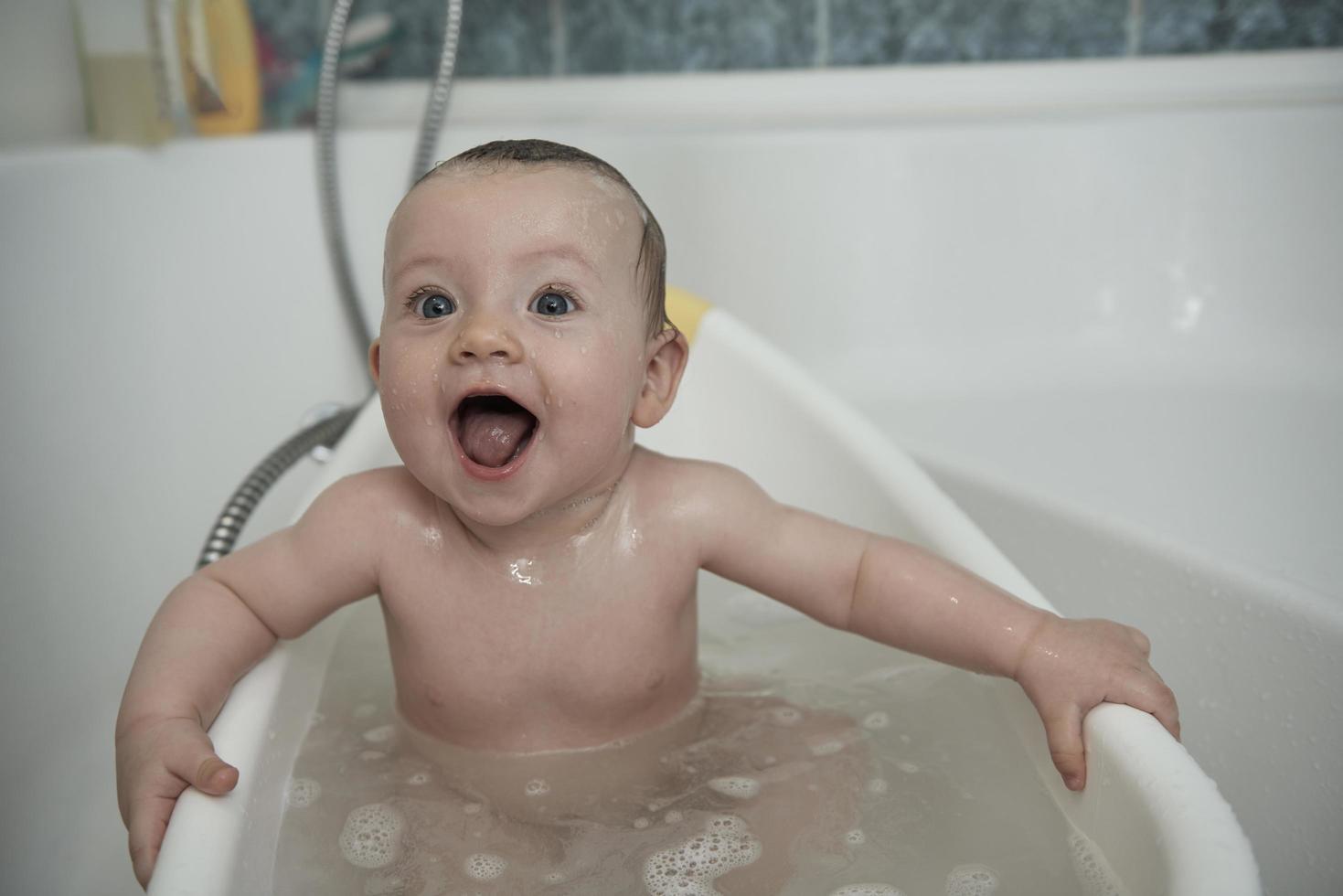 schattig weinig baby meisje nemen een bad foto