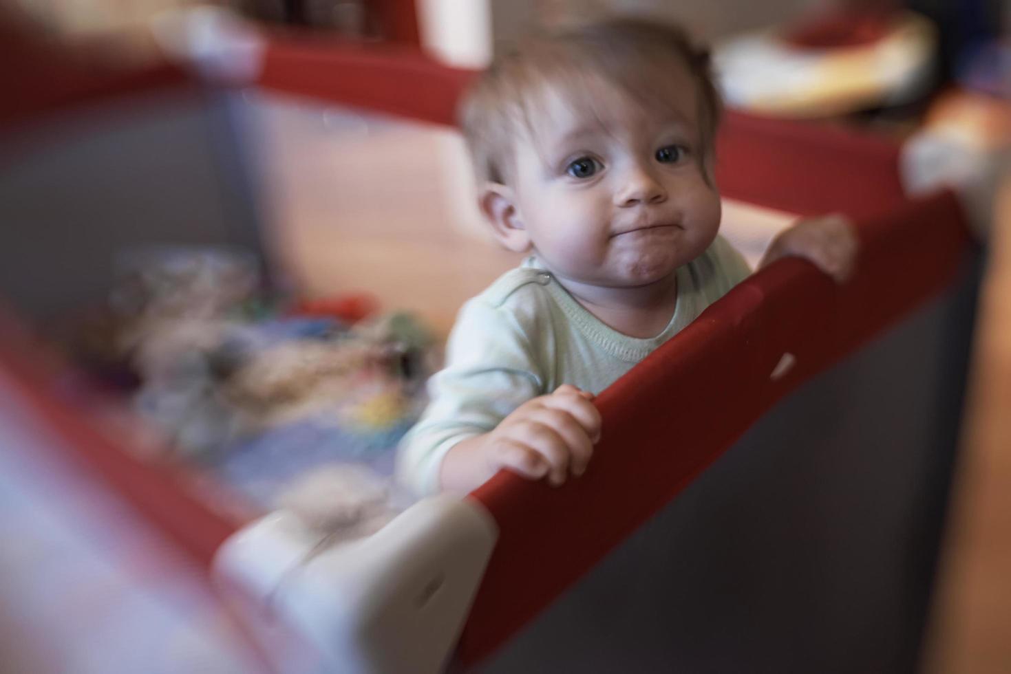 schattig weinig baby spelen in mobiel bed foto