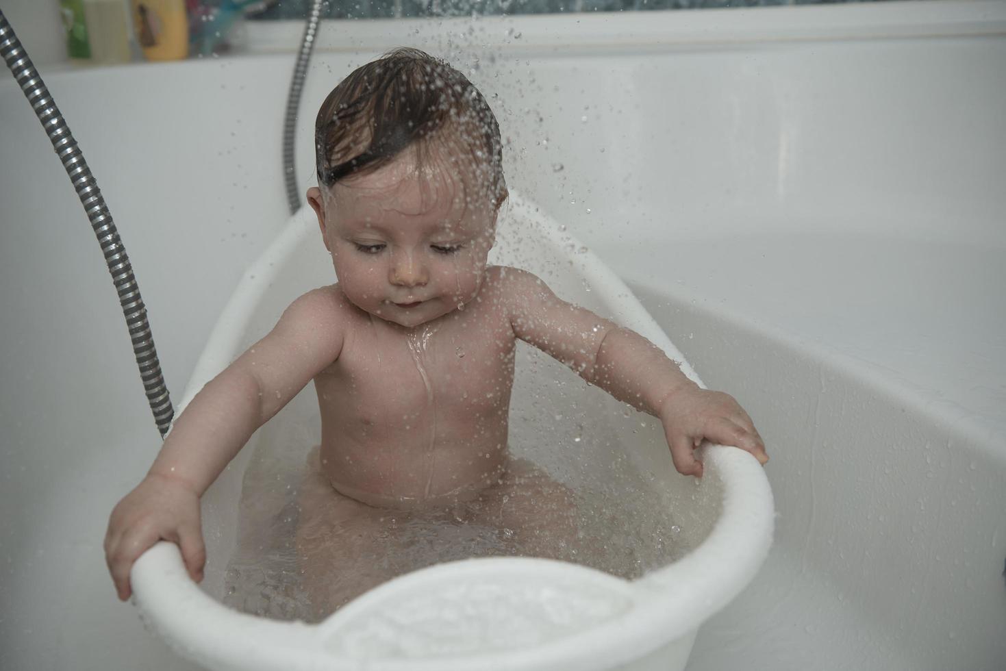 schattig weinig baby meisje nemen een bad foto