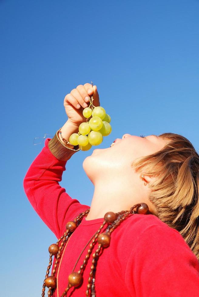 meisje aan het eten druiven foto