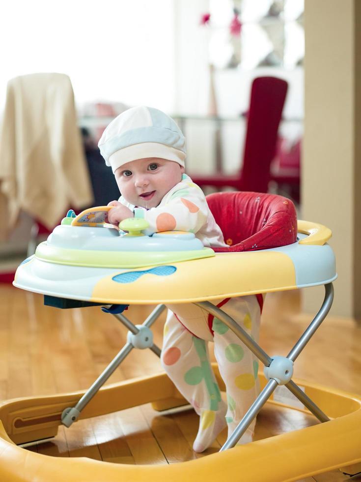 baby aan het leren naar wandelen in wandelaar foto