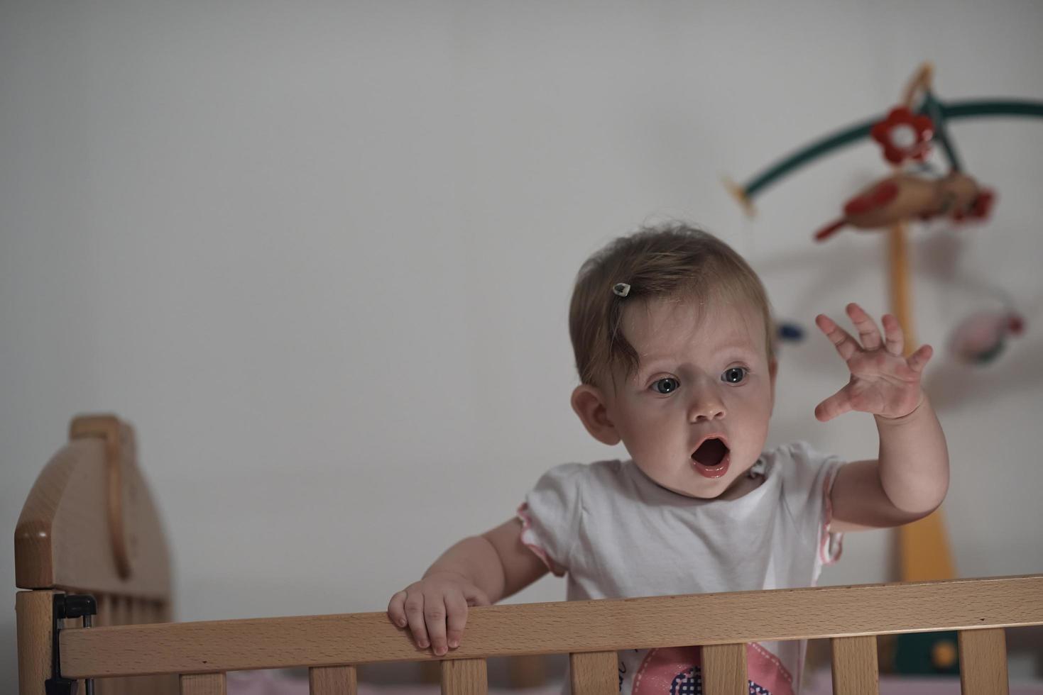 schattig weinig een jaar oud baby en maken eerste stappen in bed foto