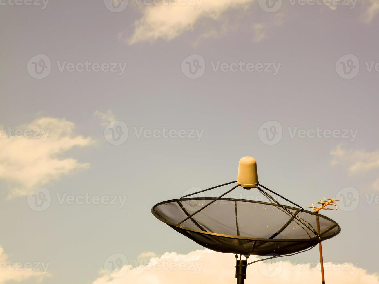 tv-satellietschotel 's avonds op het dak van het huis foto