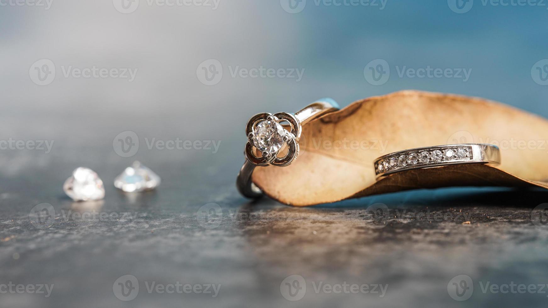 close-up van een diamanten verlovingsring geplaatst op een blad. liefde en bruiloft concept. foto