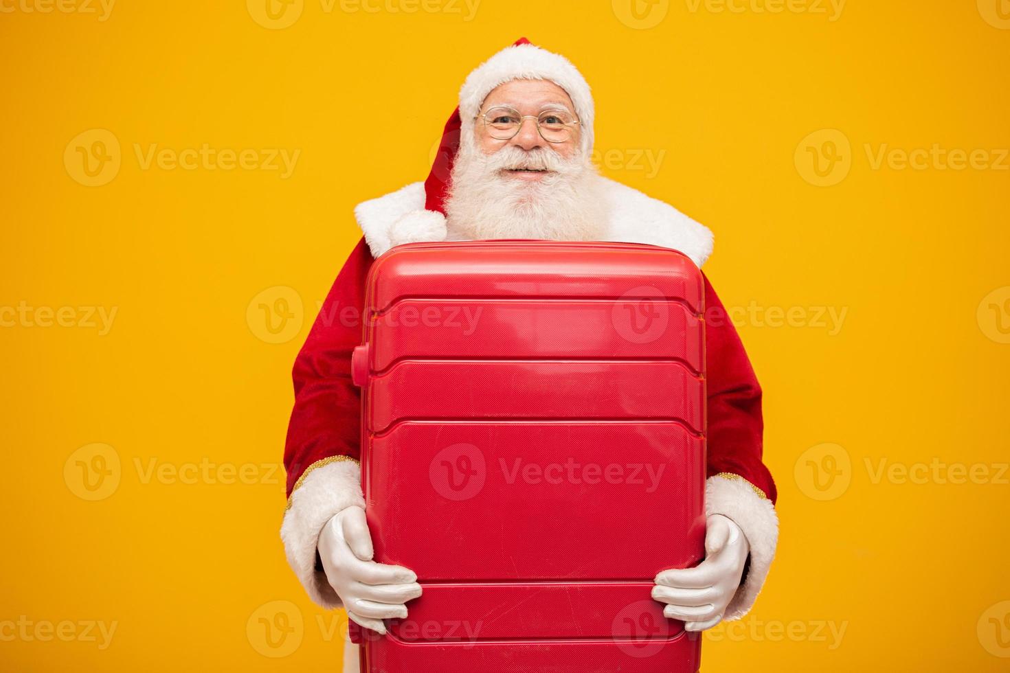 kerstman met zijn koffer. nieuwjaarsreisconcept. kerstman op de luchthaven. foto