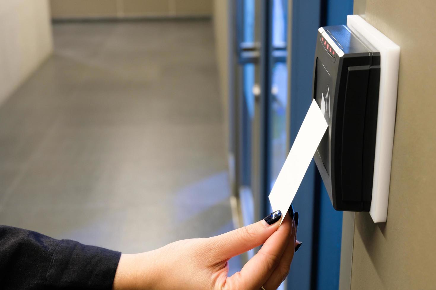 vrouwen hand reiken om rfid-sleutelkaart te gebruiken voor toegang tot kantoorgebouw en werkruimte. in gebouwbeveiliging alleen voor geautoriseerde persoon foto