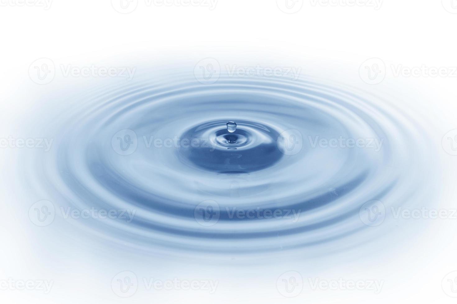 spatwater, water druipend op het wateroppervlak blauwe watergolf geïsoleerd op een witte achtergrond foto