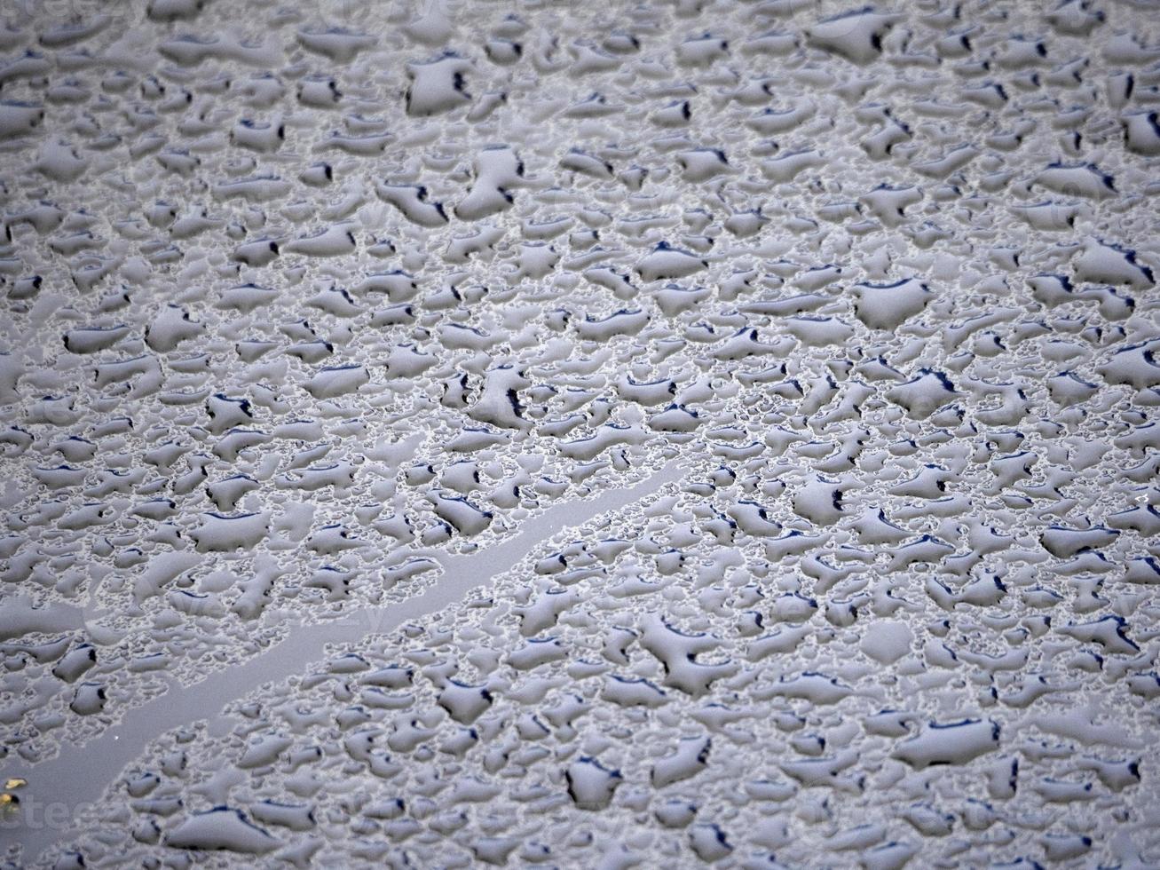 regen druppels Aan blauw metaal dichtbij omhoog macro foto