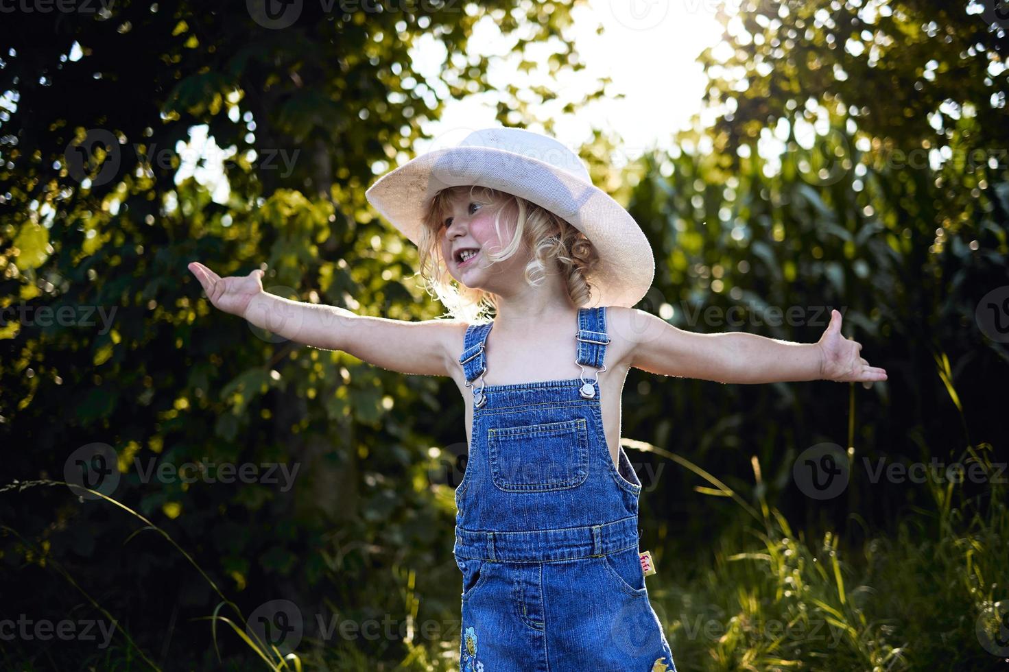 klein blond meisje dat op het platteland speelt foto