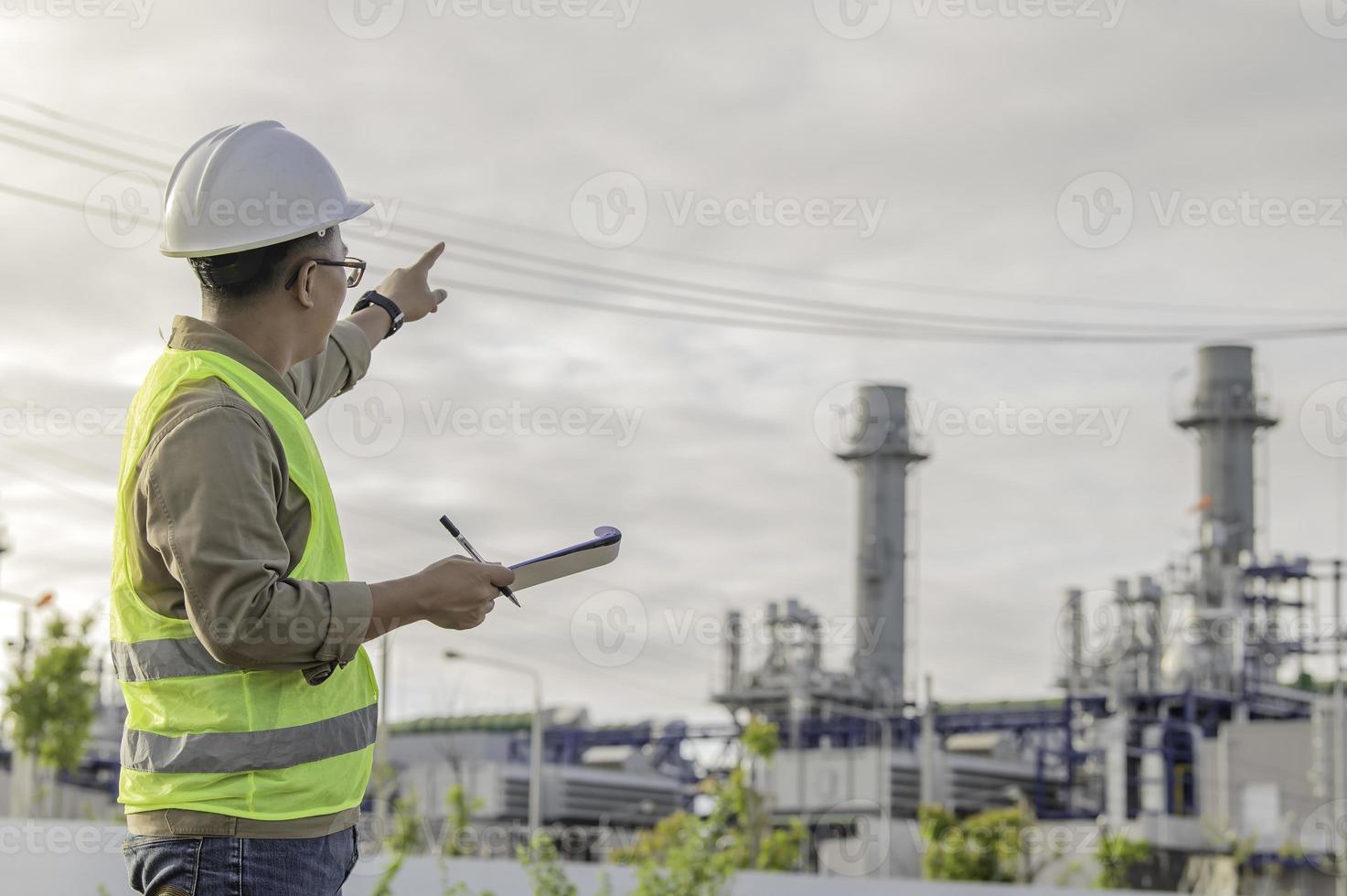 aziatische man petrochemisch ingenieur aan het werk bij de fabriek van de olie- en gasraffinaderij, de mensenarbeider man ingenieur werkcontrole bij de productie van de energiecentrale foto