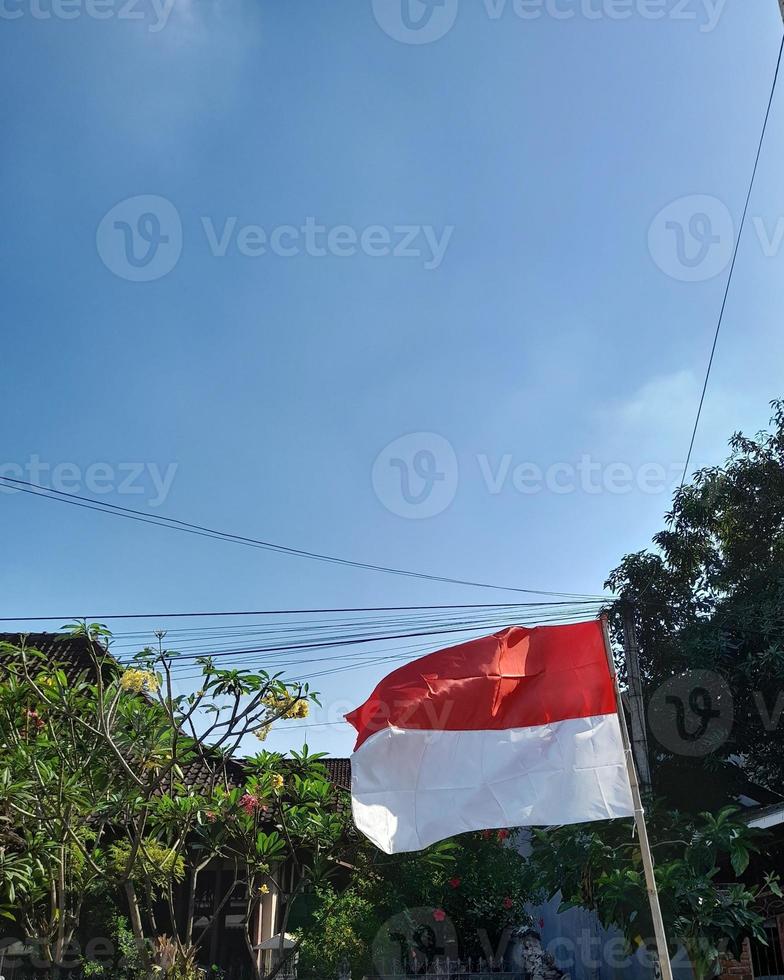 de Indonesisch vlag is rood en wit met een helder blauw lucht achtergrond foto
