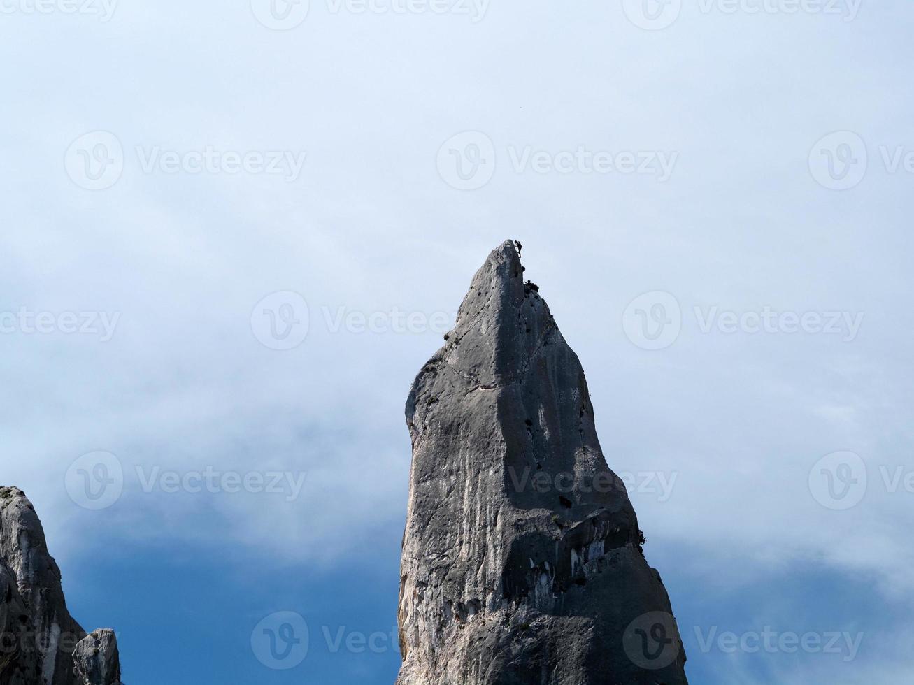 klimmer Aan goloritze rots klif door de zee Sardinië Italië foto