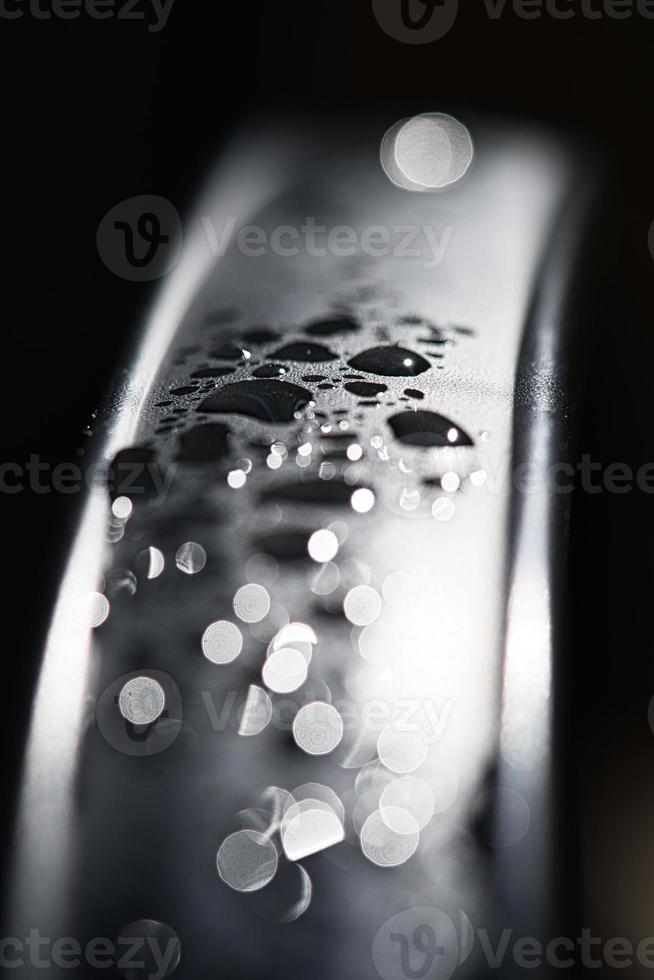 water druppels abstract en met wazig achtergrond schijnt Aan een metaal oppervlakte van een stoel foto