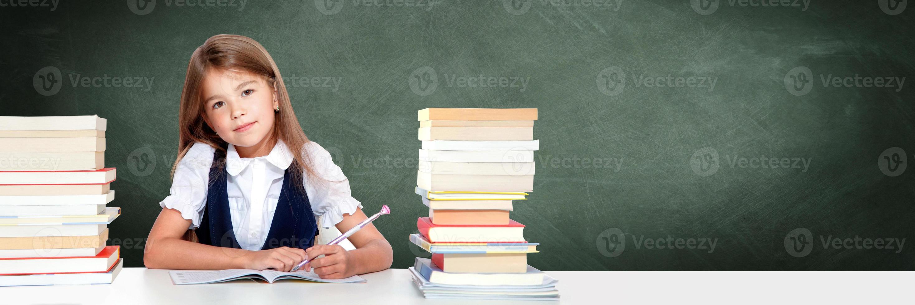 gelukkig en schattig tiener school- meisje schrijft in een boek of notitieboekje foto